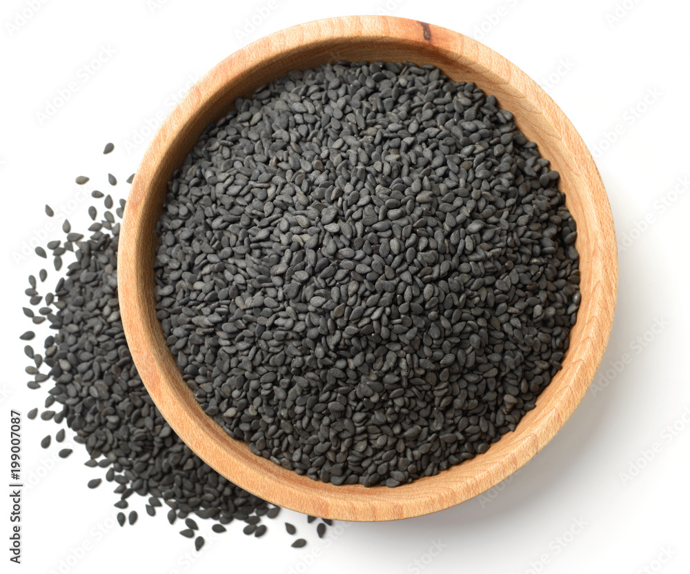dried black sesame seeds in the wooden plate, isolated on white, top view dried black sesame seeds in the wooden plate, isolated on white, top view
