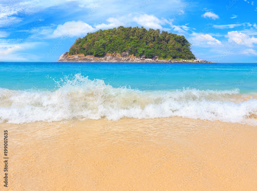 Picturesque view of Andaman sea with strong and high waves in Phuket island, Thailand. Seascape with yellow sand and blue sky. Tropical beach at the exotic island.