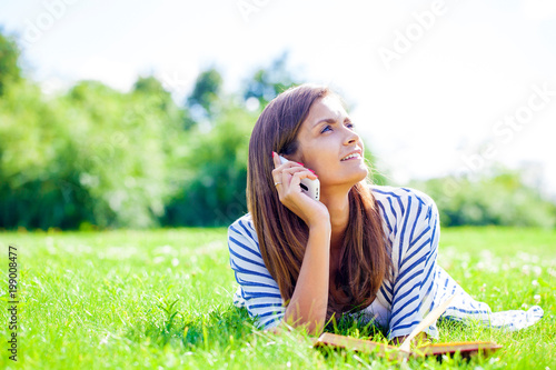 Portrait of beautiful caucasian smiling brunette young woman calling by phone © Andrey_Arkusha