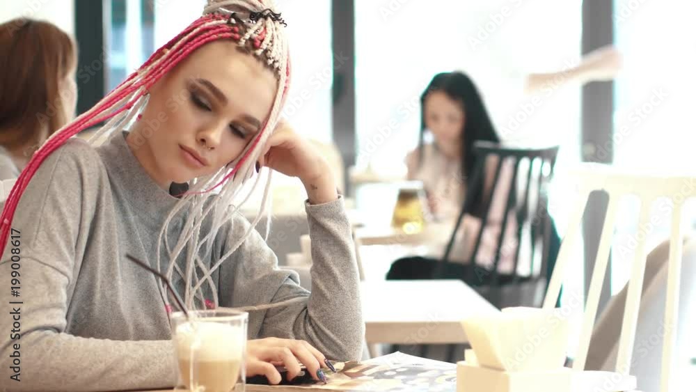 portrait of a girl with dreadlocks in a cafe. a teenager with an unusual appearance. subculture of modern youth portrait of a girl with dreadlocks in a cafe. a teenager with an unusual appearance. subculture of modern youth