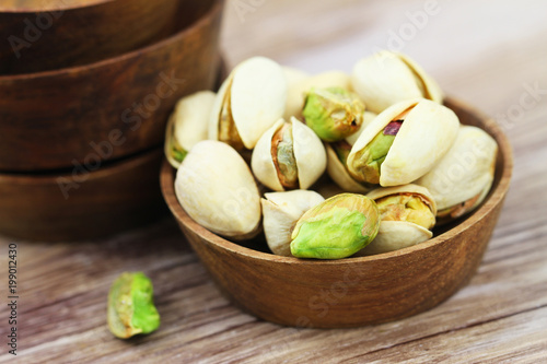 Close up of pistachio nuts in wooden bowl
