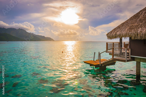 Evening with sunset in Moorea. Overwater bungalow on the side with breathtaking lagoon, French Polynesia