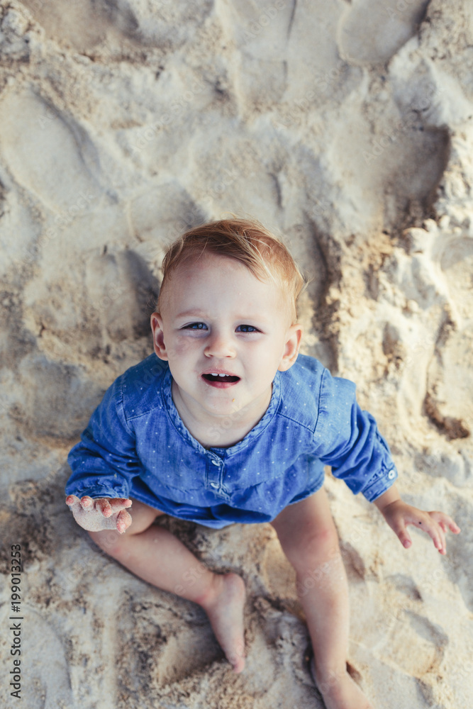 Portrait of Little girl sitting on sea shore sand Portrait of Little girl sitting on sea shore sand