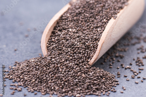 Chia seeds in scoop on grey stone background