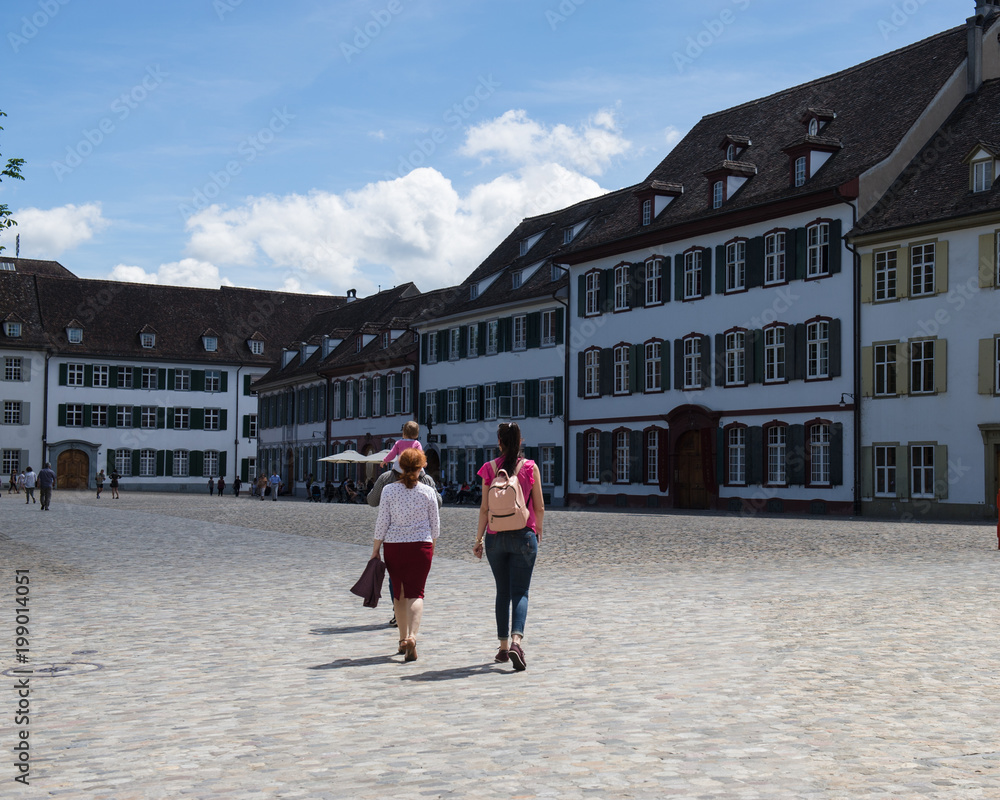 Tourists travel in the old part of the city of Basel.