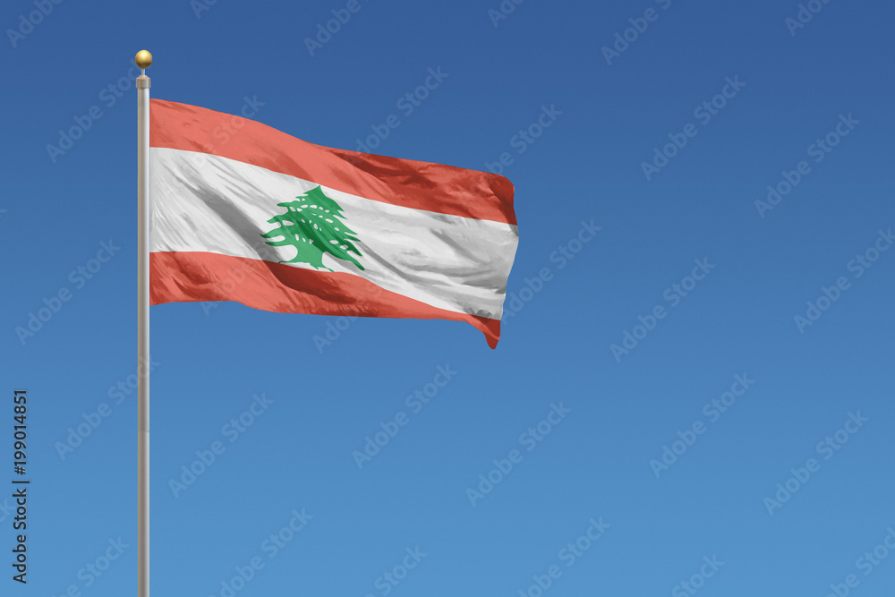 Naklejka premium Flag of Lebanon in front of a clear blue sky