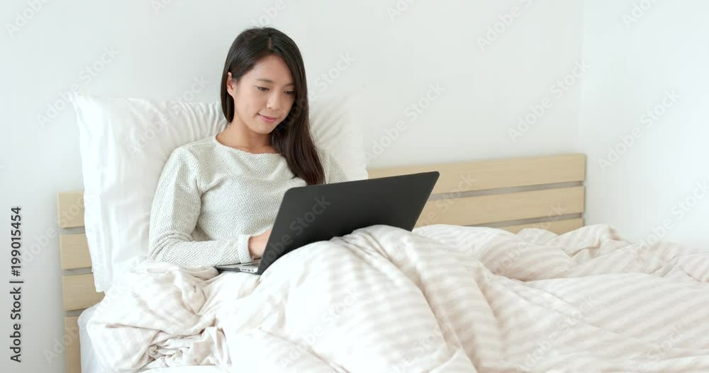 Woman use of notebook computer on bed Woman use of notebook computer on bed