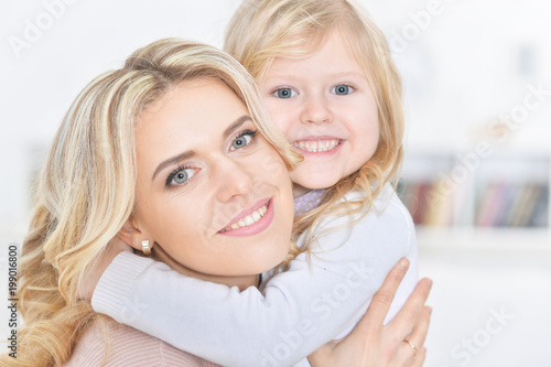 young happy woman with little girl embracing
