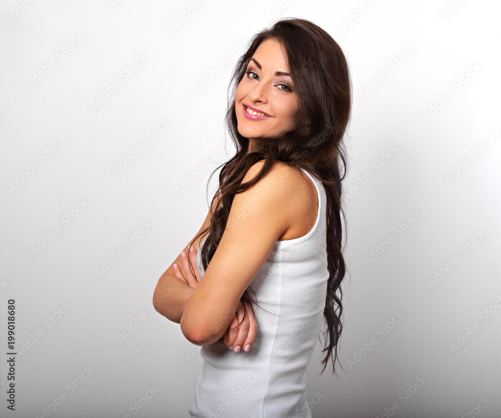 Beautiful positive happy woman in shirt with toothy smile folded arms the long brown hair on white background. Beautiful positive happy woman in shirt with toothy smile folded arms the long brown hair on white background.