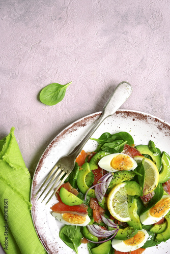 Avocado salad with salted salmon, baby spinach and eggs.Top view with copy space.