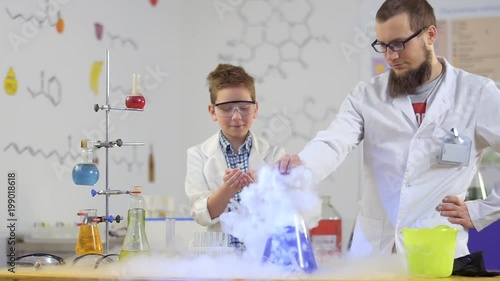 Two laboratory assistans explores dry ice and his impact on the acid photo