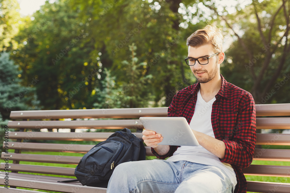 Surprised man in the park with tablet oudoors Surprised man in the park with tablet oudoors