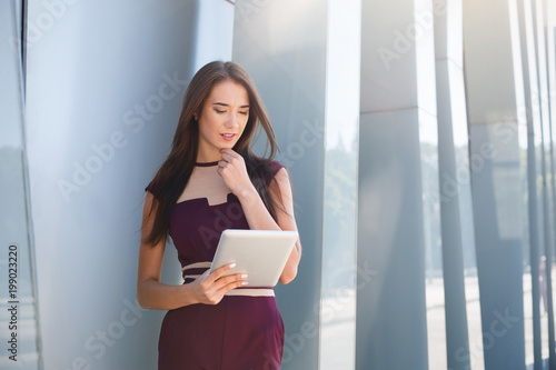 Businesswoman working with tablet outdoors