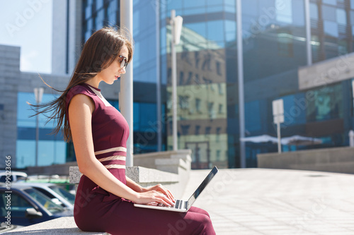Businesswoman working with laptop outdoors