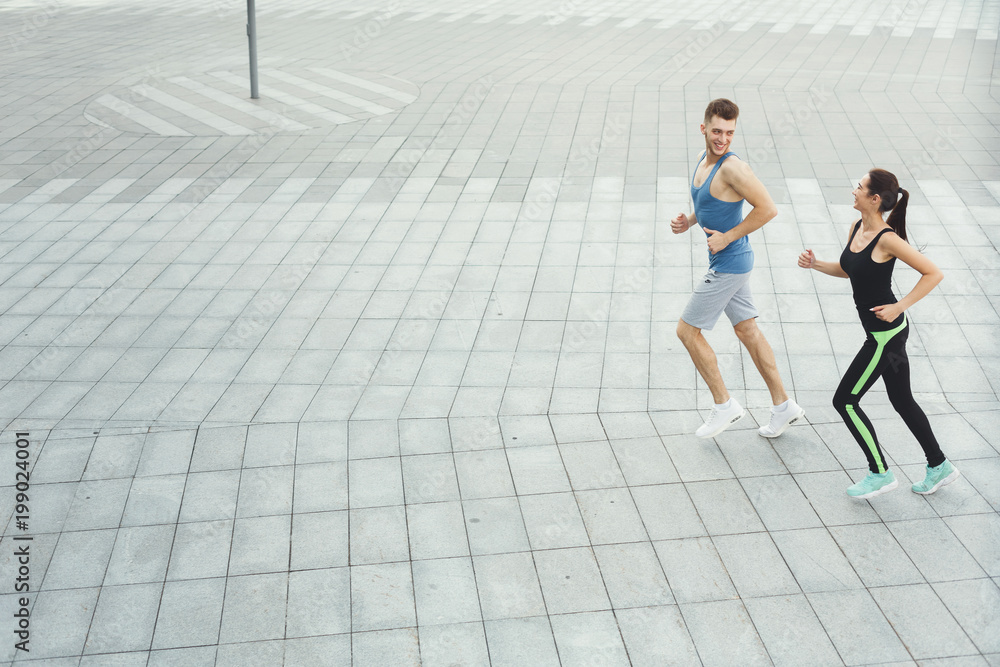 Young woman and man jogging in city copy space Young woman and man jogging in city copy space