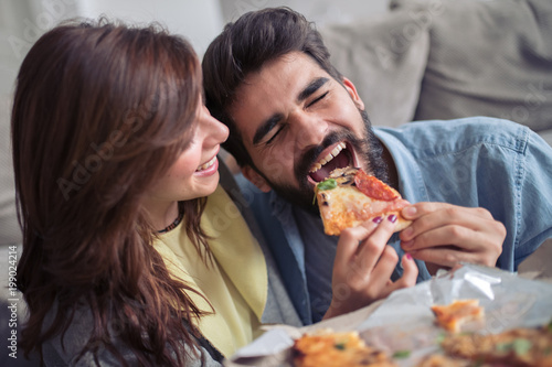 Couple eating pizza at home