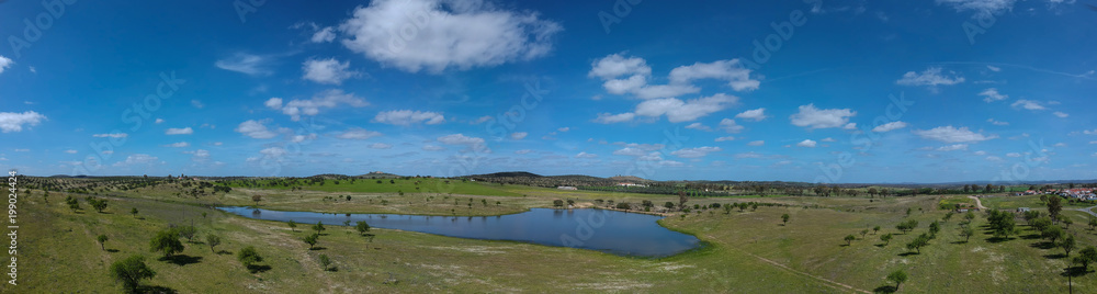Aerial view of colorful agricultural field with a lagoon in spring with blue sky in background. Portugal