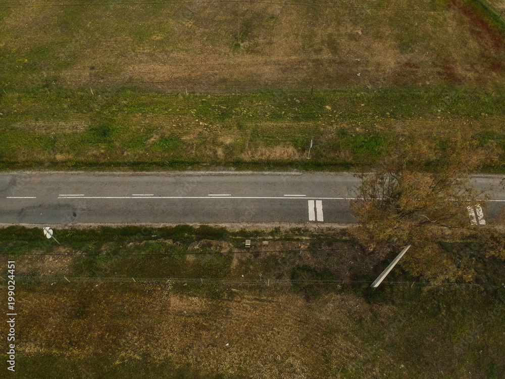 Fototapeta premium aerial view of village road and harvest fields