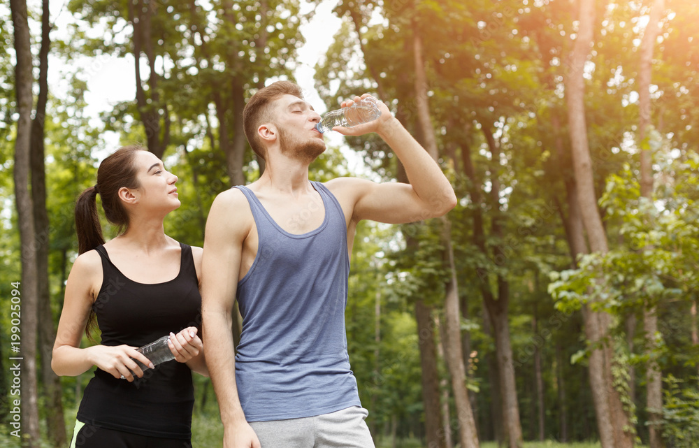 Obraz premium Couple runners is having break, drinking water