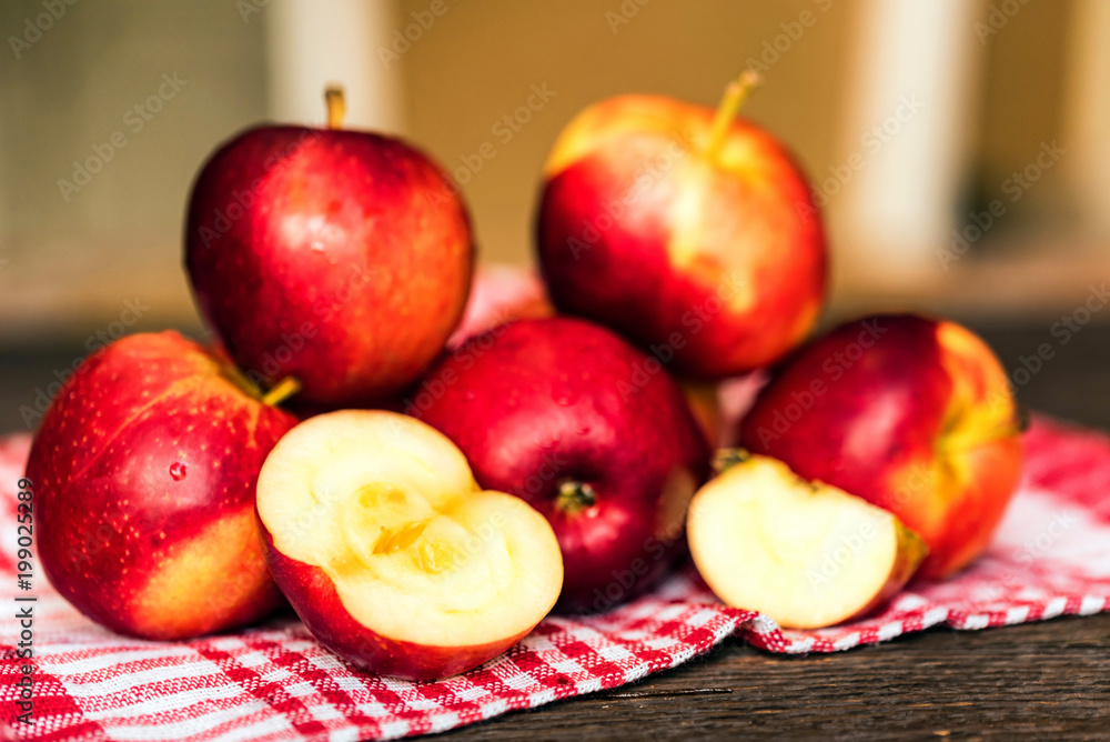 Whole and cut red apples on checked tablecloth Whole and cut red apples on checked tablecloth