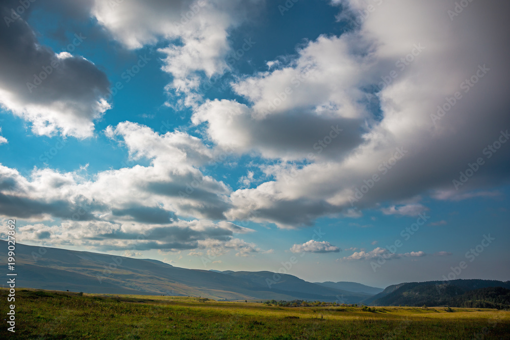 Mountain landscape panorama with dramatic clouds on sky, summer travel background