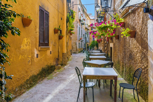 Fototapeta Naklejka Na Ścianę i Meble -  Cafe tables and chairs outside in old cozy street in the Positano town, Italy