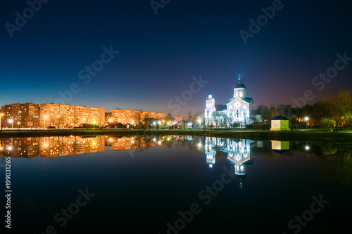 Evening View Of Illuminated Alexander Nevsky Orthodox Church And Residential Area Behind City Lake.
