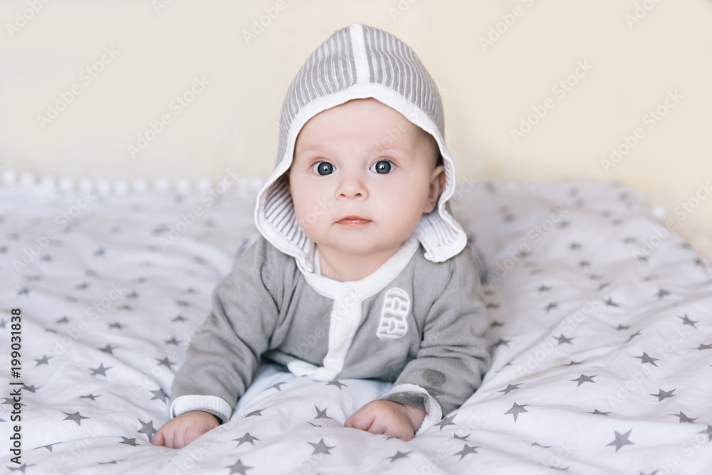 Small baby boy lying on stomach and raising his head awhile looking surprised and smiling cute, newborn Small baby boy lying on stomach and raising his head awhile looking surprised and smiling cute, newborn
