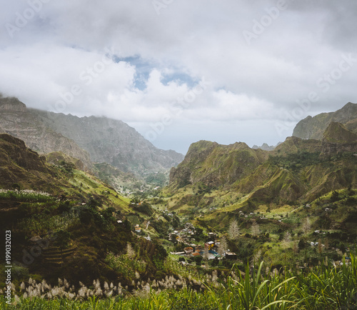 Cape Verde. Gorgeous panoramic view of famous fertile Paul Valley. Agriculture terraces of sugarcane in vertical valley sides, people dwellings, rugged peaks and motion clouds on horizon photo