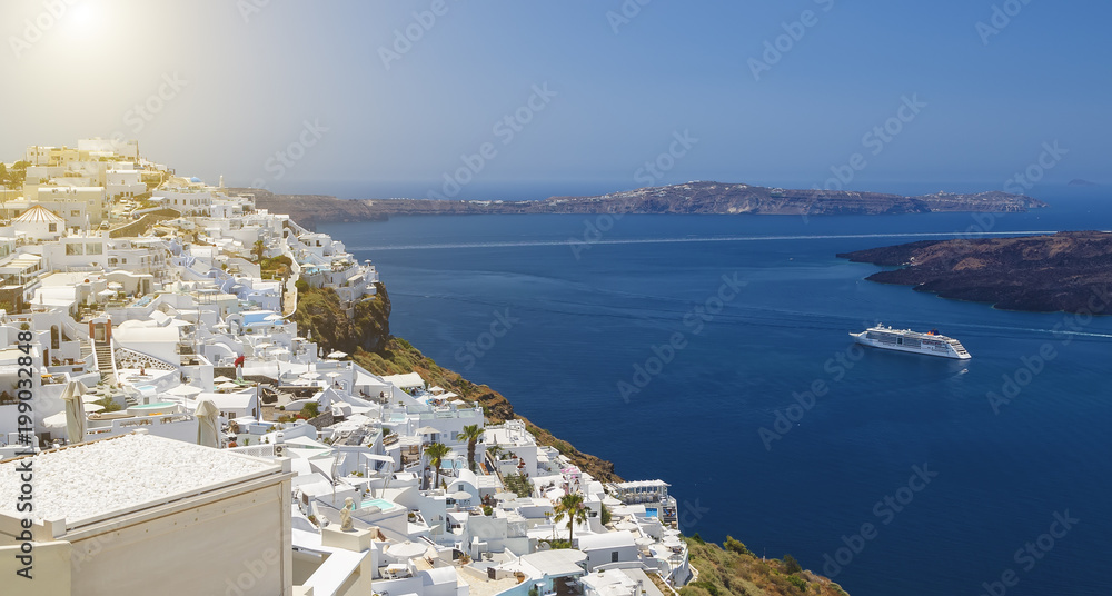 Beautiful panoramic view from touristic Fira town to caldera and volcano and cruise ship at summer sunny day. Santorini(Thira) island.Seascape.