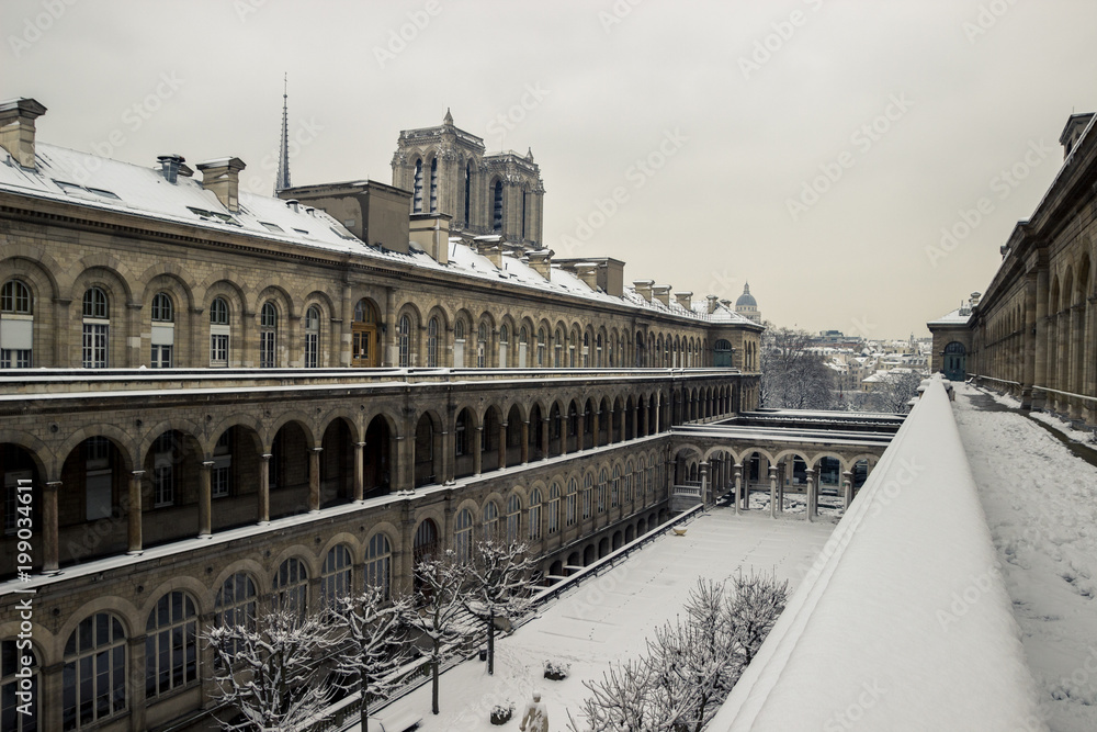 Fototapeta premium The Hotel Dieu under the snow, in Paris, with the cathedrale of Notre Dame in the background.