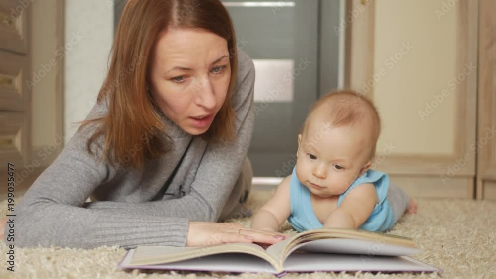 Young mother, read a book to her small boy, in the living room Young mother, read a book to her small boy, in the living room