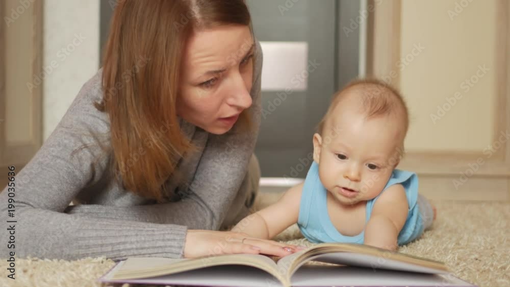 Young mother, read a book to her small boy, in the living room