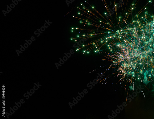Colorful bright green fireworks and smoke in the night sky background
