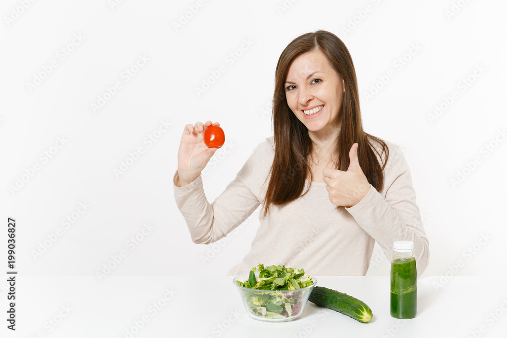 Woman at table with green detox smoothies, fresh salad in glass bowl, tomato, cucumber isolated on white background. Proper nutrition, vegetarian food, healthy lifestyle, dieting concept. Copy space. Woman at table with green detox smoothies, fresh salad in glass bowl, tomato, cucumber isolated on white background. Proper nutrition, vegetarian food, healthy lifestyle, dieting concept. Copy space.
