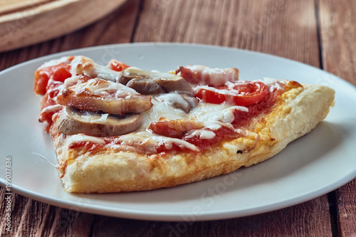 Homemade pizza milano, traditional italian pizza, tomato sauce, mozzarella cheese, bacon, mushrooms,