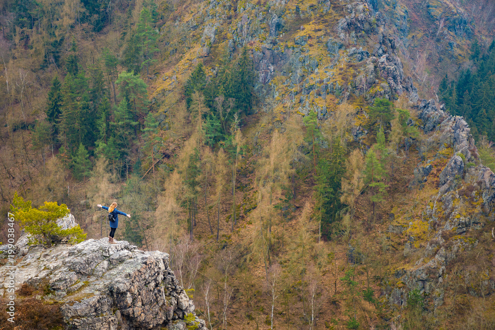 The girl on the rock in mountain, small human in nature