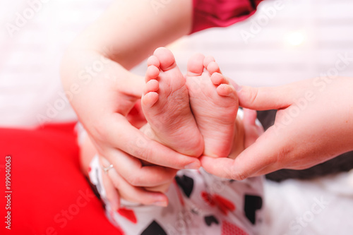 Newborn baby feet parents holding in hands