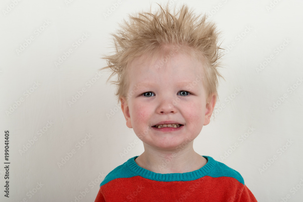 Naklejka premium Happy Caucasian blonde with microphone. Drummer play on a new drum kit. Parents bought a drum box for training. Child in bright clothes with new chopsticks in hands happy at home. Bright emotions