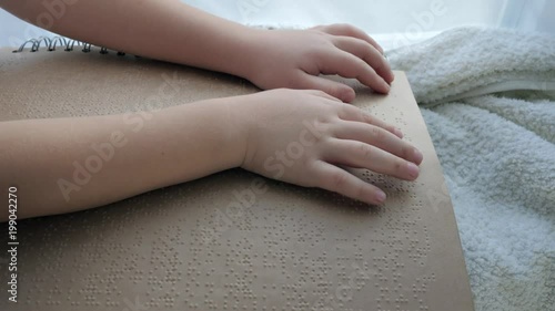people with disabilities, blind child reading book of characters font close-up