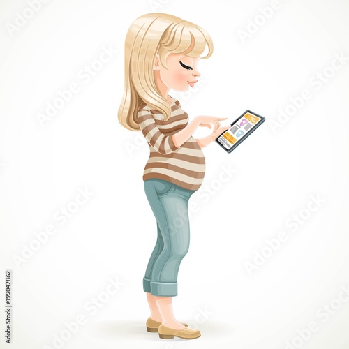 Cute pregnant  blond woman uses an electronic tablet standing in the profile on a white background