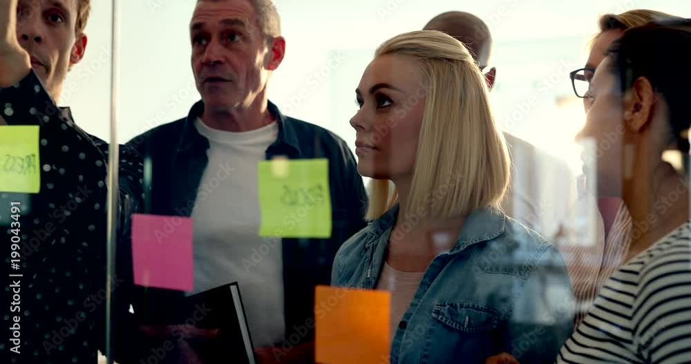 44Group of diverse businesspeople standing together in a modern office brainstorming with sticky notes on a glass wall 44Group of diverse businesspeople standing together in a modern office brainstorming with sticky notes on a glass wall