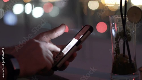 Man browsing photos on smartphone at night
