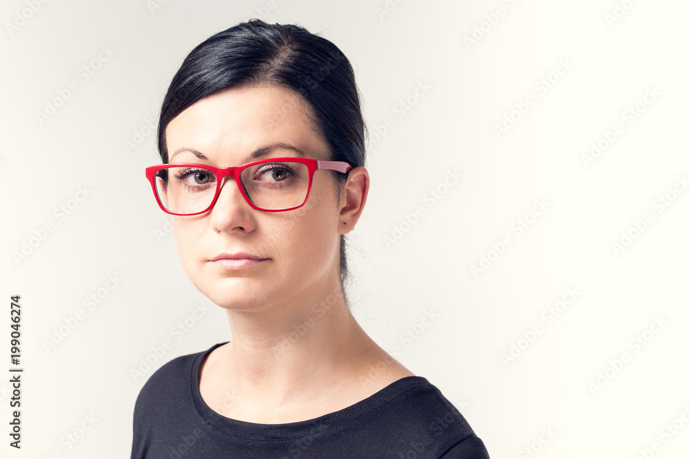 Portrait of a young woman with black hair and red glasses. Portrait of a young woman with black hair and red glasses.
