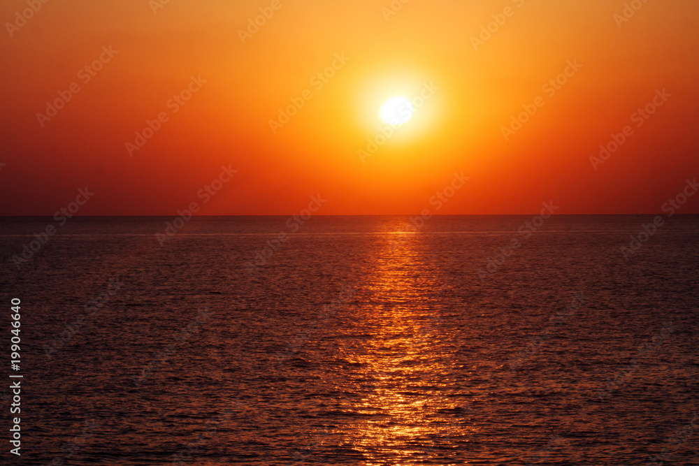Beautiful sunset on the sea with shallow waves in summer hot evening poster background