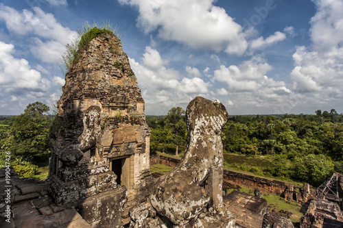 A temple with treess and roots over the walls in the Angkor Wat Complex near Sim Reap in Cambodia photo