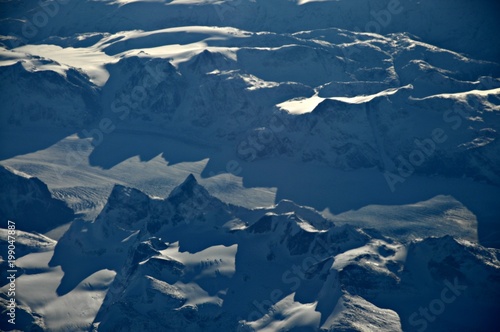 Icy mountains in Greenland seen from the airplane window