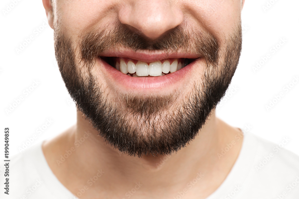 Obraz premium Young man with beautiful smile on white background. Teeth whitening