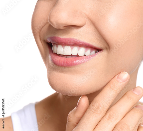 Young woman with beautiful smile on white background  closeup. Teeth whitening