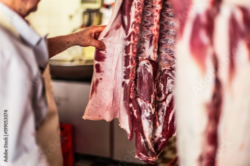 close up of the ribs and raw meat of a fresh killed pig hanging at the slaughterhouse  © shellygraphy